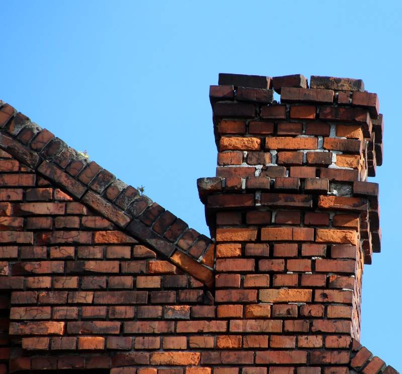 Damaged chimney on an Brookline home showing cracks and missing mortar